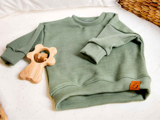 Oversize Sweater aus natürlicher Wolle in der Farbe Salbei / grün für Babys von 0-2 Jahren.