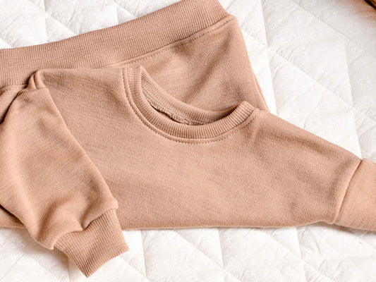 Baby Oversize Sweater aus Bio-Wolle in der Farbe Sand / Beige für Babys im Alter von 0-2 Jahren.