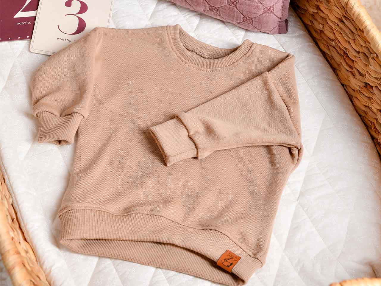 Baby Oversize Sweater aus Bio-Wolle in der Farbe Sand / Beige für Babys im Alter von 0-2 Jahren.