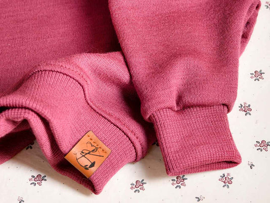 Oversize Sweater für Babys aus natürlicher Wolle in der Farbe Beere. Für Babys im Alter von 0-2 Jahren.